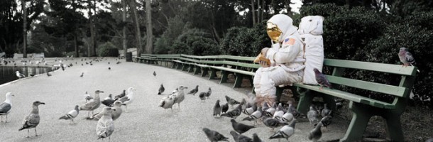 Astronaut feeding pigeons on a park bench
